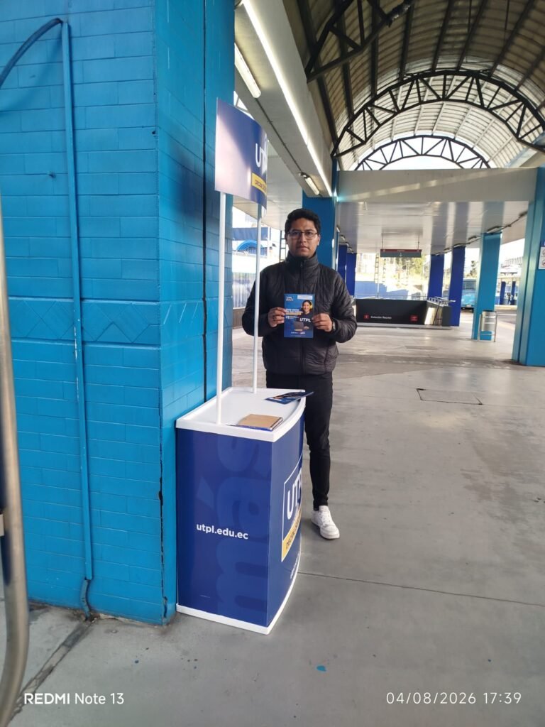 Promotor UTPL con material publicitario en estación de transporte