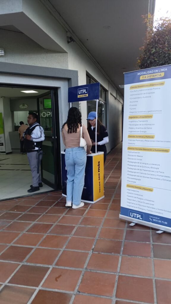 Promotora UTPL atendiendo stand en punto de alta circulación