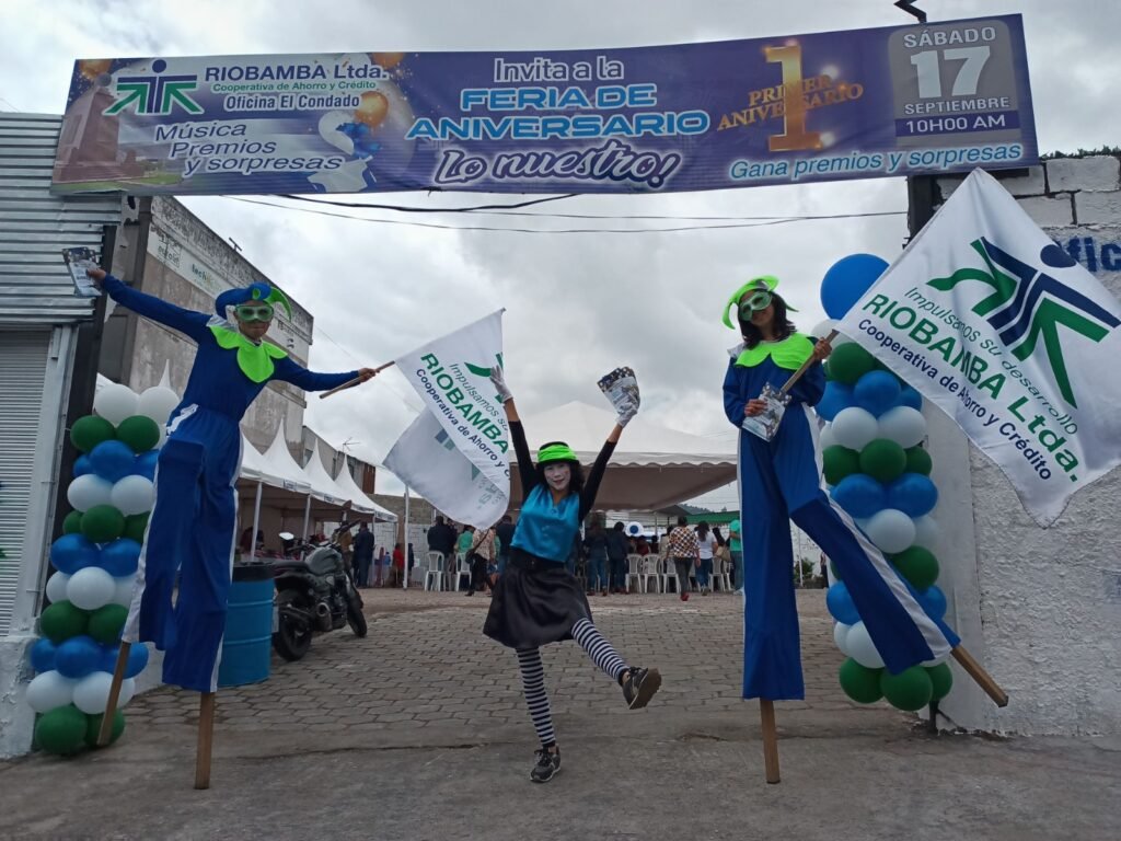 Zanqueros con banderas en feria de aniversario de Cooperativa Riobamba Ltda., activación BTL